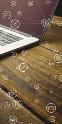 digital composite of laptop with communication graphics